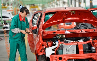 Chinese worker assembles EV