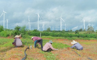 farmers near wind turbines in Asia